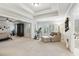 Spacious bedroom with tray ceilings, a ceiling fan, plenty of natural light, and a relaxing seating area at 1870 Marcia Overlook Dr, Cumming, GA 30041