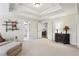 Bright bedroom with tray ceilings, neutral carpeting, and decorative shelving and furnishings at 1870 Marcia Overlook Dr, Cumming, GA 30041