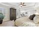 Bright bedroom with tray ceilings, ceiling fan, seating area, and dark wood furnishings at 1870 Marcia Overlook Dr, Cumming, GA 30041