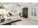 Bedroom features neutral carpeting, tray ceilings, a ceiling fan, and dark wood furniture at 1870 Marcia Overlook Dr, Cumming, GA 30041