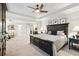Bedroom with tray ceilings, ceiling fan, and dark wood furniture and easy access to the bathroom at 1870 Marcia Overlook Dr, Cumming, GA 30041