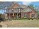 Inviting two-story home with a brick facade, covered porch, and meticulously maintained landscaping at 1870 Marcia Overlook Dr, Cumming, GA 30041