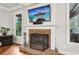 Living room fireplace with brick surround, sleek TV, and decorative accents for a warm, inviting ambiance at 1870 Marcia Overlook Dr, Cumming, GA 30041