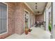 Charming front porch featuring brick accents, ceiling fans, and comfortable seating area at 1870 Marcia Overlook Dr, Cumming, GA 30041