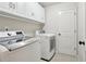 Modern laundry room with white cabinetry, a folding table, and new washer and dryer units at 1870 Marcia Overlook Dr, Cumming, GA 30041