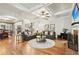 Spacious living room with hardwood floors, coffered ceiling, and a cozy fireplace with a TV above at 1870 Marcia Overlook Dr, Cumming, GA 30041