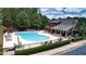 Aerial view of outdoor community pool surrounded by lounge chairs, tables, umbrellas, trees and a building at 1870 Marcia Overlook Dr, Cumming, GA 30041