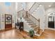 Elegant foyer with hardwood floors, a staircase with decorative iron railings, and abundant natural light at 1870 Marcia Overlook Dr, Cumming, GA 30041