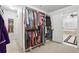 Organized walk-in closet with extensive shelving and hanging space, leading to a bright bathroom with a soaking tub at 1870 Marcia Overlook Dr, Cumming, GA 30041