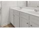 Bathroom vanity with double sinks, wood look flooring, and white cabinets at 321 Daybreak Dr, Acworth, GA 30102