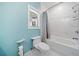 Well-lit bathroom features a shower-tub combo, white tiled walls, and a toilet for added convenience at 717 Chamberlain Sw Cir, Marietta, GA 30008