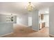Open-concept living area with a chandelier and adjacent kitchen featuring white appliances at 13304 Waldrop Cv, Decatur, GA 30034