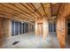 Unfinished basement shows exposed ceiling and framing for future rooms at 7746 New Castle Way, Jonesboro, GA 30236
