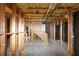 Unfinished basement shows exposed ceiling, framing, and stairway to main level at 7746 New Castle Way, Jonesboro, GA 30236