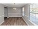 Well-lit dining room with gray walls, white trim, wood-like floors, and bright windows at 7746 New Castle Way, Jonesboro, GA 30236