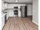 Bright kitchen with stainless steel appliances, white cabinets, and wood-like floors at 7746 New Castle Way, Jonesboro, GA 30236