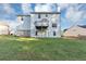 Rear exterior view of the home showing a white siding, balcony, and a well-maintained backyard at 7746 New Castle Way, Jonesboro, GA 30236