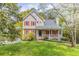 Charming two-story home with red shutters and a cozy front porch surrounded by lush greenery at 116 Shefield Pl, Douglasville, GA 30134