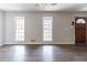 Bright living room with windows, new floors, neutral paint, and a wooden entry door at 116 Shefield Pl, Douglasville, GA 30134