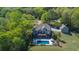 Aerial view of the house featuring an in-ground swimming pool, a back patio, and lush landscaping at 20 Rivercreek Xing, Kingston, GA 30145