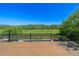 Spacious wooden back deck with black metal railing overlooking green fields and trees at 20 Rivercreek Xing, Kingston, GA 30145