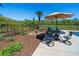 Outdoor patio area features a dining set with umbrella, palm tree, and lush landscaping at 20 Rivercreek Xing, Kingston, GA 30145
