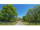 A home surrounded by lush greenery, a long driveway, and dark fencing at 20 Rivercreek Xing, Kingston, GA 30145
