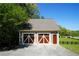 A detached garage with a two-car door and driveway, set in a grassy yard with trees at 20 Rivercreek Xing, Kingston, GA 30145