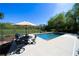 Sparkling in-ground pool with umbrella covered table and chairs, and scenic views of the backyard at 20 Rivercreek Xing, Kingston, GA 30145
