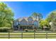 Back of the home, featuring a large deck, balconies, lush landscaping, and a fenced-in yard at 20 Rivercreek Xing, Kingston, GA 30145