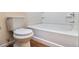 Clean bathroom showcasing a toilet, tub with tiled surround, and wood-look flooring at 3355 Waldrop Trl, Decatur, GA 30034