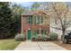 Charming brick townhome featuring a green door, shutters, and well-manicured landscaping at 3355 Waldrop Trl, Decatur, GA 30034