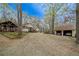A wide view of a house featuring gravel driveway, covered porch, detached garage and wooden pergola at 5 Colonial Club Se Dr, Acworth, GA 30102