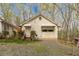Rustic garage exterior featuring a single-car garage door, a separate entrance, and natural surroundings at 5 Colonial Club Se Dr, Acworth, GA 30102