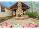 Charming home exterior with a stone fireplace and covered outdoor kitchen, perfect for outdoor gatherings at 5 Colonial Club Se Dr, Acworth, GA 30102