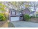 Split-level home featuring neutral siding, red shutters, and attached garage at 3094 Calumet Nw Cir, Kennesaw, GA 30152