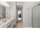 Clean bathroom featuring double vanity, tile flooring, a glass-enclosed shower, and modern fixtures at 3823 Briarstone Cv, Snellville, GA 30039