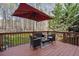 Outdoor deck with seating surrounded by mature trees in a serene setting at 3823 Briarstone Cv, Snellville, GA 30039