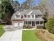 Beautiful two-story home with a well-kept lawn, two-car garage, and a cozy front porch with white columns at 3823 Briarstone Cv, Snellville, GA 30039