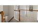 Bright hallway with carpet, wood railing, and arched window floods the space with natural light at 3823 Briarstone Cv, Snellville, GA 30039