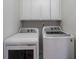 Well-equipped laundry room with a side-by-side washer and dryer and overhead cabinets at 3823 Briarstone Cv, Snellville, GA 30039