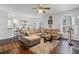 Bright living room featuring a comfortable sectional sofa, ceiling fan, and hardwood floors at 3823 Briarstone Cv, Snellville, GA 30039