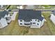 Aerial view of a modern white home with a dark roof, surrounded by a lush green lawn and neighborhood streets at 7785 Wild Violet Dr, Cumming, GA 30040