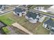 An aerial view of a new home construction with a lush lawn in a desirable neighborhood near a pond at 7785 Wild Violet Dr, Cumming, GA 30040