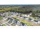 An aerial shot of a neighborhood with a pond and homes surrounded by green trees on a sunny day at 7785 Wild Violet Dr, Cumming, GA 30040