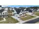 An aerial view of a neighborhood, showcasing a white brick home with a black roof and two-car garage at 7785 Wild Violet Dr, Cumming, GA 30040