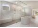 Spacious bathroom featuring a luxurious soaking tub, marble tiles, and a glass-enclosed shower at 7785 Wild Violet Dr, Cumming, GA 30040