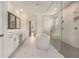 Bathroom with white marble floors, a soaking tub, a double vanity, and a frameless shower at 7785 Wild Violet Dr, Cumming, GA 30040