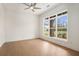 A bedroom with hardwood floors, a ceiling fan, neutral paint and a large window at 7785 Wild Violet Dr, Cumming, GA 30040