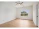 Bedroom with hardwood floors, neutral paint, a window, and a ceiling fan at 7785 Wild Violet Dr, Cumming, GA 30040